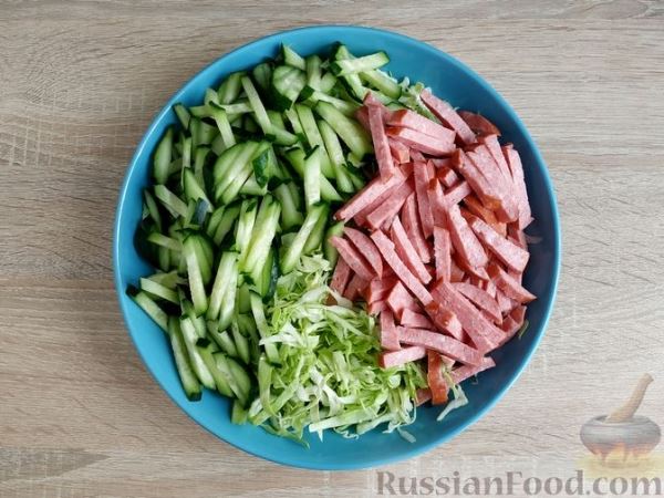Салат из молодой капусты, колбасы, огурцов и сухариков